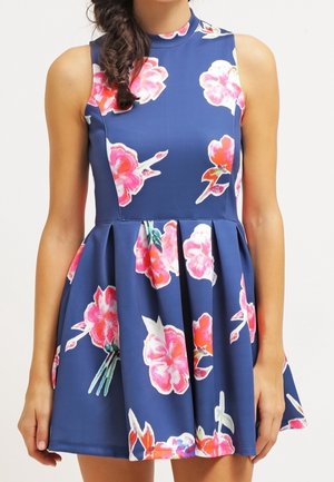 Sleeveless navy blue dress with pink and white large floral prints, fitted bodice, high neckline, and pleated flared skirt.