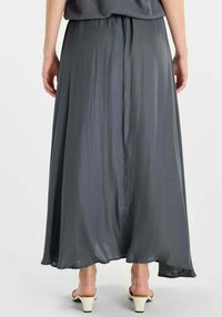 Lange, vloeiende grijze rok gemaakt van lichtgewicht stof met een gladde textuur, voorzien van een geplooide taille en een licht gebogen zoom.
