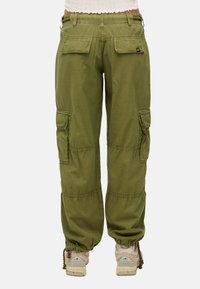 Cargo pants van olijfgroene stof hebben een elastische tailleband, twee achterzakken en een trekkoord aan de onderkant. Inclusief zijcargozakken voor opslag.