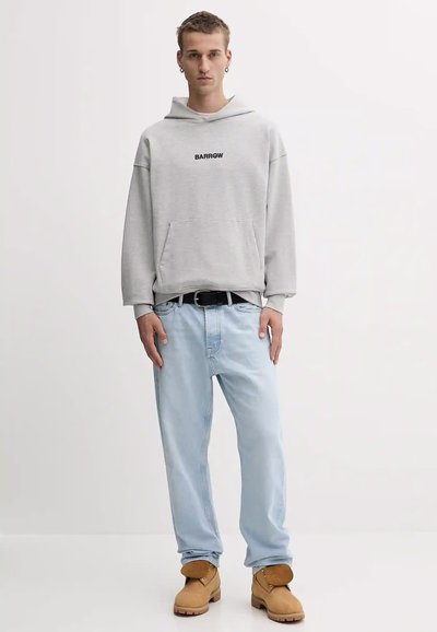 Felpa grigia con cappuccio e logo nero "BARROW", jeans azzurri chiari e stivali color sabbia. Presenta una tasca a marsupio e una vestibilità comoda.