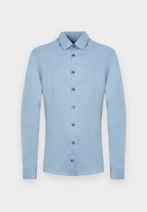 Ανοιχτό μπλε ανδρικό πουκάμισο με μακριά μανίκια, κλείσιμο με κουμπιά και μυτερό γιακά, εμφανιζόμενο σε λευκό φόντο.