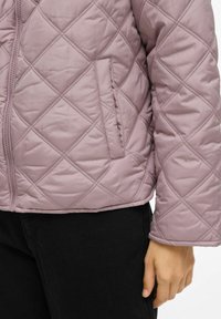 Pakuotė priglausta striukė šviesiai mauve spalvos, su užtrauktuku, šonine siuvimo schema, šoniniu kišeniu ir banguotomis rankovėmis. Suteikta su juodomis kelnėmis.