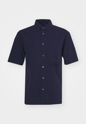 Tamno mornarski kratki rukav košulja izrađena od tkanine s glatkom teksturom. Ima klasični ovratnik, prednje dugme i džep na prsima.