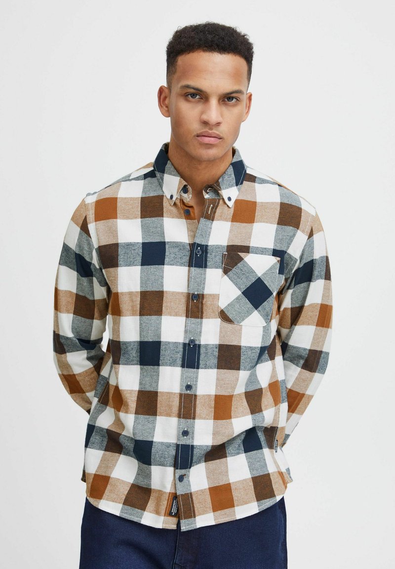 Camicia a maniche lunghe in flanella da uomo in plaid bianco, blu navy e marrone. Presenta un colletto button-down e una tasca sul petto. Texture morbida.