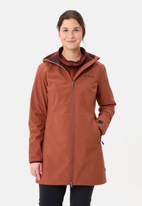 Rust-colored waterproof jacket with a zip closure, adjustable hood, and pockets. Soft texture and sleek design suitable for outdoor wear.