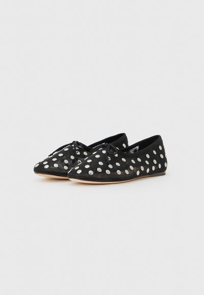 Ballerines noires à pois blancs ; avec un bout pointu, une texture douce et un détail de nœud à l'avant. Semelle fine.