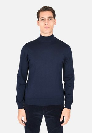Maglione a collo alto ribbed di colore blu navy realizzato in morbido tessuto a maglia. Design attillato con maniche lunghe e una silhouette semplice e moderna.