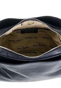 Borsa a tracolla in pelle nera con chiusura a zip, con fodera interna beige stampata con il logo "Pierre Cardin". Texture liscia, design strutturato.