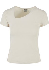 Krämfärgad t-shirt med kort ärm och rundad halsringning, tillverkad av mjukt bomullstyg, med en figurnära silhuett och utan synliga mönster.