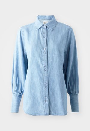 Camisa de ganga azul clara com gola, fecho com botões na frente e mangas longas bufantes. Apresenta uma textura subtil e botões coordenados.