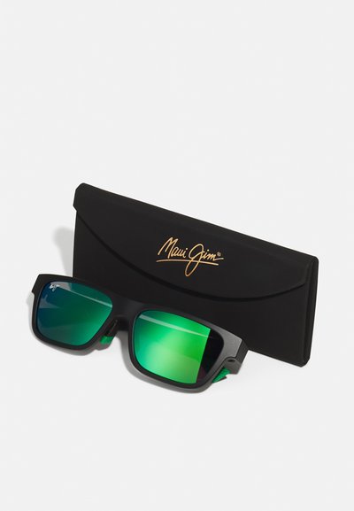 Black sunglasses with green gradient lenses, square shape, matte finish, featuring a logo on the case. Accompanied by a sleek black case.