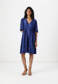 Blue, pleated dress with a V-neck and short puff sleeves, cinched at the waist. Features a flowing skirt and a smooth, glossy texture.