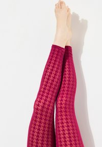 Collant fucsia con motivo a scacchi, realizzati in materiale trasparente, con un design aderente che si adatta alle gambe.