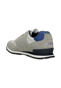 Sneaker in suede grigio con pannelli in rete, accentuazione del tallone blu navy, suola intermedia bianca e suola in gomma nera. Presenta una chiusura con lacci e dettagli del logo.