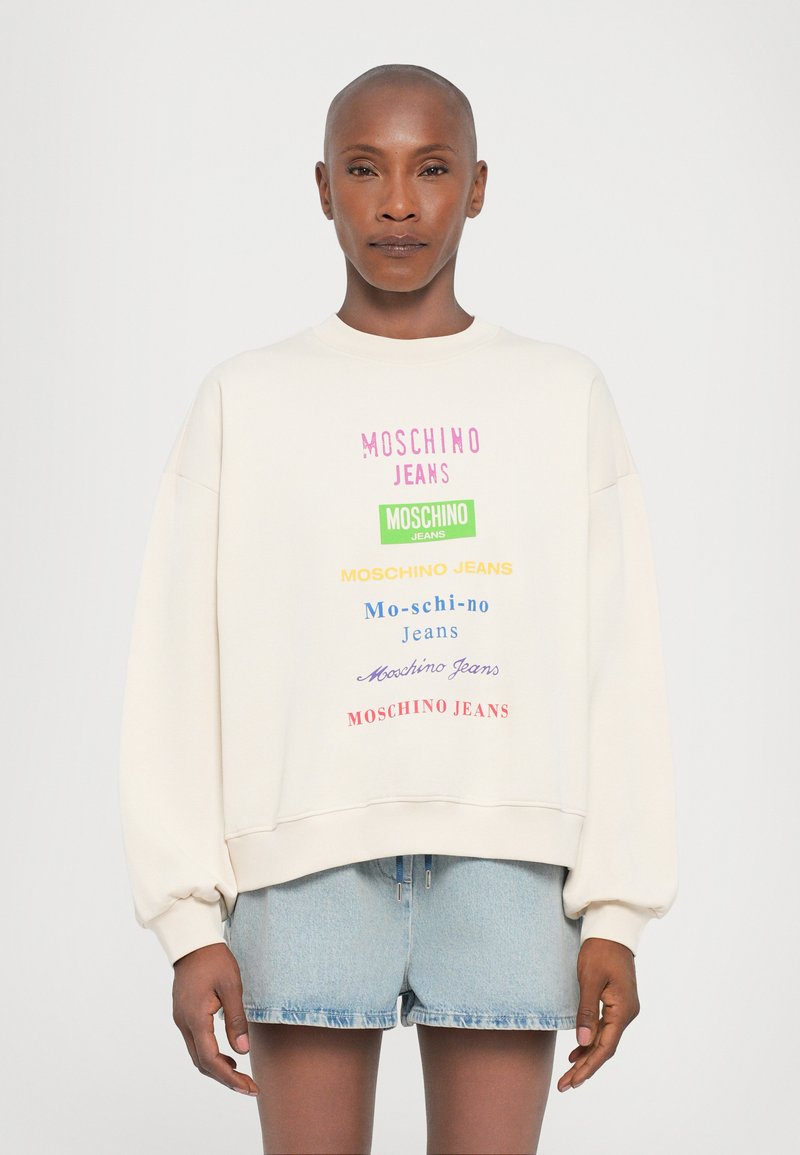 Krémová mikina s multicolornými textovými logami "MOSCHINO JEANS" v rôznych písmach. Dizajn má spadnuté ramenné švy a rebrované lemy.