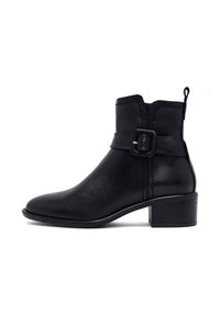 Bottines en cuir noir avec un bout rond, une fermeture éclair sur le côté et une accent de boucle sur la sangle au-dessus de la cheville. Talon bas empilé.