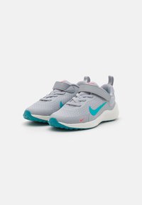 Baskets de sport gris clair avec une tige en maille texturée, des accents aqua, une sangle Velcro et une semelle intermédiaire blanche avec une semelle extérieure turquoise.