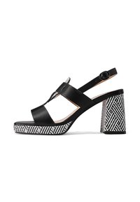Sandalo con tacco in pelle nera con cinturino alla caviglia, dotato di un tacco a blocco con un motivo geometrico bianco e nero e una superficie liscia.