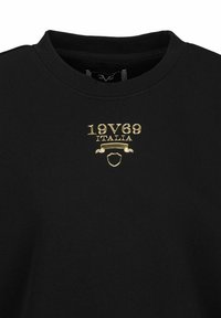 Black sweatshirt featuring gold embroidered text "19V69 ITALIA" above a shield. The design includes a round neck and a smooth texture.