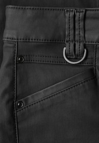 Svarta konstläder byxor med hög midja, som har en metallring, synliga sömmar och en design med framfickor.