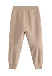 Pantaloni jogger in pile color beige chiaro con cintura a coste. Caratterizzati da tasche laterali e gambe affusolate con polsini aderenti. Texture morbida.