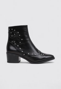 Botas de cuero negro hasta el tobillo con punta afilada, con acentos de tachuelas metálicas y un tacón bajo en bloque, que presentan un patrón decorativo texturizado.