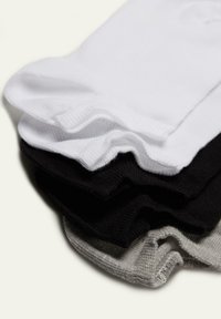 Vier paar sokken gestapeld: wit, zwart, donkergrijs en lichtgrijs. Elk met een gladde textuur en geribbelde manchetten.