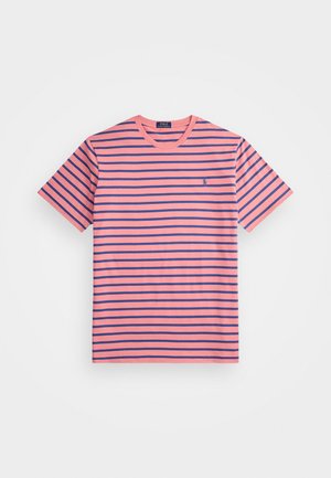 Camiseta a rayas en rosa claro y azul marino. Cuello redondo, mangas cortas, tejido de algodón. Logo pequeño notable en el lado izquierdo.