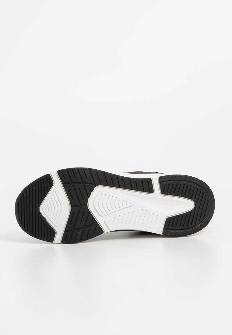 Semelle de basket noir et blanc avec un fond en caoutchouc texturé, présentant des rainures et des motifs pour une meilleure traction et un soutien optimal.