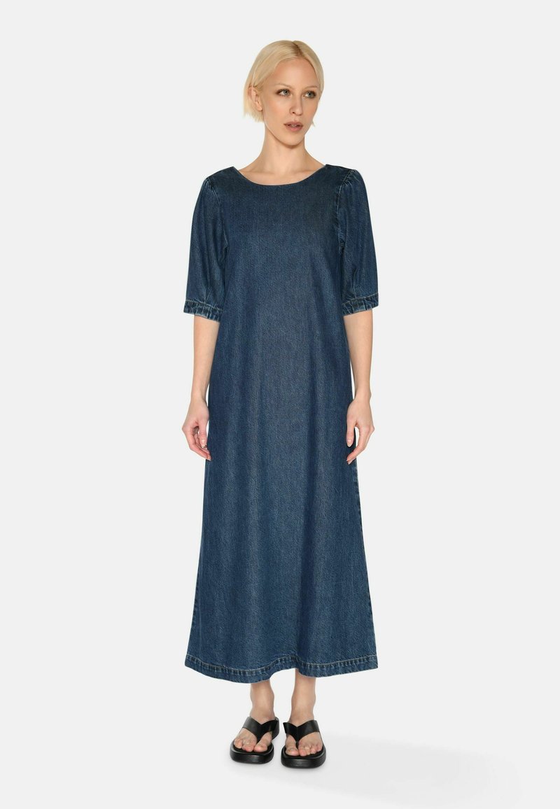Denim-maksimekko, jossa on pyöreä kaula-aukko, puffit lyhyet hihat ja suora siluetti. Tumansinisestä kankaasta, vastakkain ommeltu sauma ja sivusaumat.