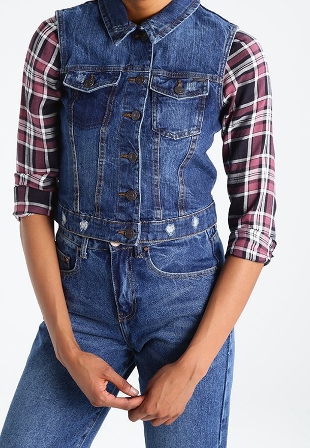 Jeansvest met kraag, voorkantzakken en knoopsluiting, over een langemouw, geruit shirt in donkerrood, wit en zwart.