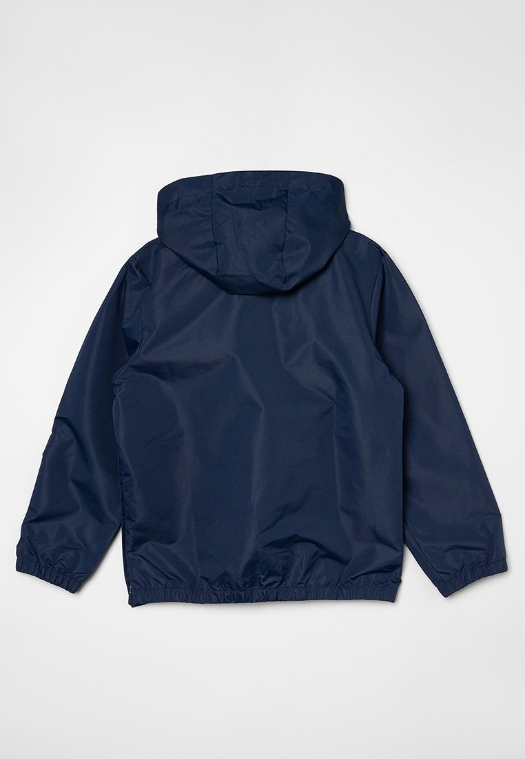 Chaqueta ligera de color azul marino con capucha, puños elásticos y dobladillo inferior. Fabricada con un material suave y resistente al agua, con un diseño sencillo.