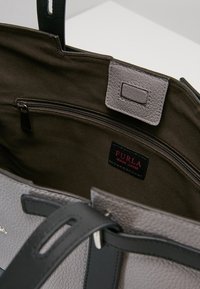 Borsa Furla in pelle grigia texturizzata con manici neri, tasca interna con zip e rivestimento in tessuto marrone.