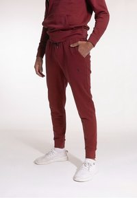 Bordeaux hoodie med framficka och matchande tapered joggers, med elastisk midja och sidfickor, kombinerad med lätta sneakers.
