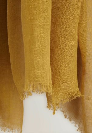 Rumena lanena tkanina z raztrganimi robovi, ki prikazuje prosojno teksturo in gladek, lahek občutek.