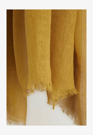Rumena lanena tkanina z raztrganimi robovi, ki prikazuje prosojno teksturo in gladek, lahek občutek.