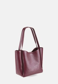 Burgundy leather tote bag with matte finish, rectangular shape, dual handles, and a scalloped top edge. Simple design, no visible hardware.