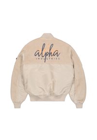 Chaqueta bomber beige con una parte superior de textura suave y una sección inferior lisa. Presenta el logotipo bordado "Alpha Industries" y puños elásticos.