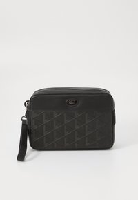 Svart syntetisk crossbody-veske med geometrisk preget mønster, glidelås-lukking og avtagbar stropp. Har en merket logo-detalj.