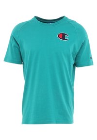 Teal tričko s krátkým rukávem Champion s červeným a černým logem na hrudi a menším logem na levém rukávu.