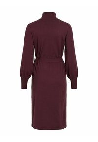 Robe à manches longues, couleur bordeaux, en tissu tricoté doux, avec un col haut et une taille ceinturée. Présente des manches bouffantes et un ourlet au niveau du genou.