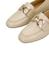 Kremowe skórzane mokasyny z ozdobą z podwójną złotą metalową klamrą z przodu, z przeszywanymi krawędziami i płaską podeszwą.