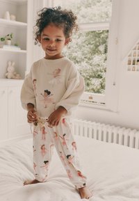 Helle, weiche Stoff-Pyjama-Set mit einem Langarmoberteil mit Ballettmotiven und locker sitzenden Hosen mit passenden Mustern.