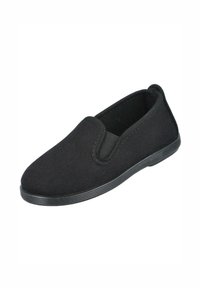 Zapatos tipo slip-on de lona negra con parte superior texturizada, paneles laterales elásticos y suela de goma. Diseño sencillo sin patrones ni adornos visibles.