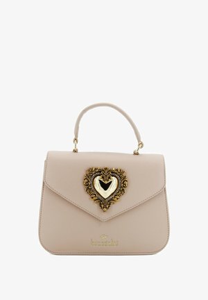 Borsa in pelle beige con una forma strutturata, dotata di una chiusura a forma di cuore dorata con dettagli ornamentali e un manico corto.