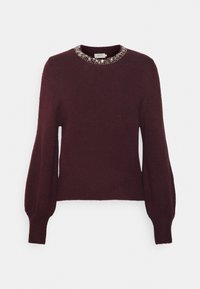 Burgundinpunainen neulepaita pyöreällä kaula-aukolla, koristeltu helmikoristellulla kauluksella. Pitkät, pallohihat resorireunuksin hihoissa ja helmassa.