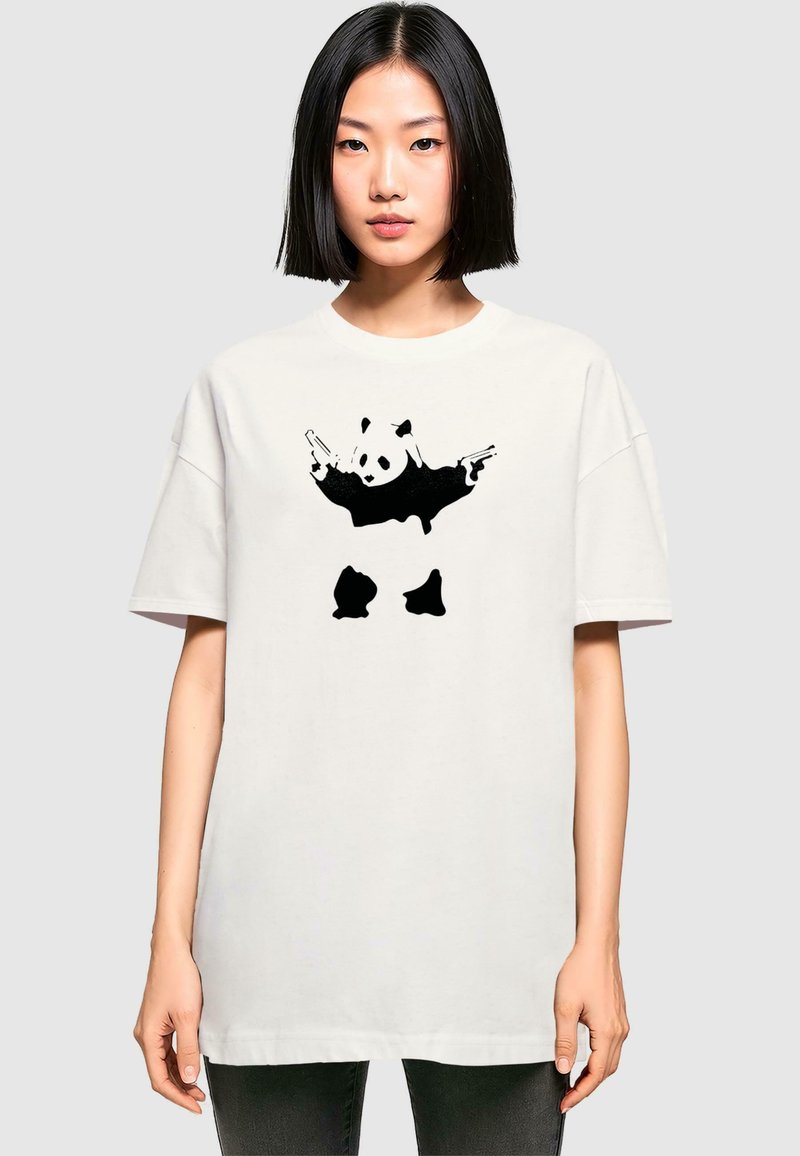 White oversized t-shirt featuring a graphic of a panda holding two guns. Short sleeves, round neckline, and a relaxed fit.