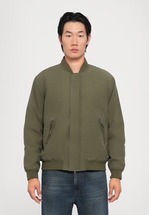 Olive green bomber jacket with a high collar, zippered side pockets, elastic cuffs, and a relaxed fit. Smooth fabric texture.
