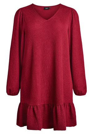Rdeča tunika obleka z dolgimi rokavi, V-izrezom, teksturirano tkanino in nabranim robom. Ima nabranje na manšetah rokavov in sproščen kroj.
