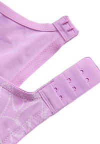 Tirante de sujetador de tela lila con dos ganchos en un extremo y tres filas de tres ojales en el otro extremo, sobre un fondo blanco.